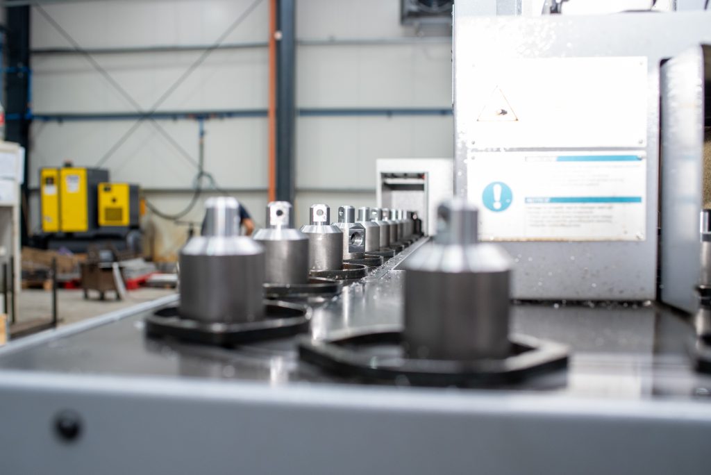 CNC machined metal components and tooling on CNC machine table, European precision manufacturing