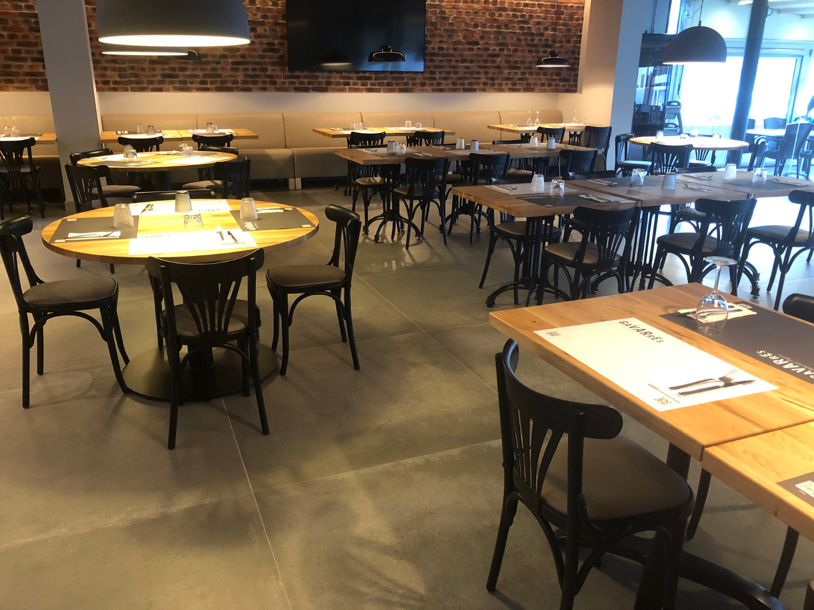 Restaurant dining room with round and rectangular solid wood tables, European furniture
